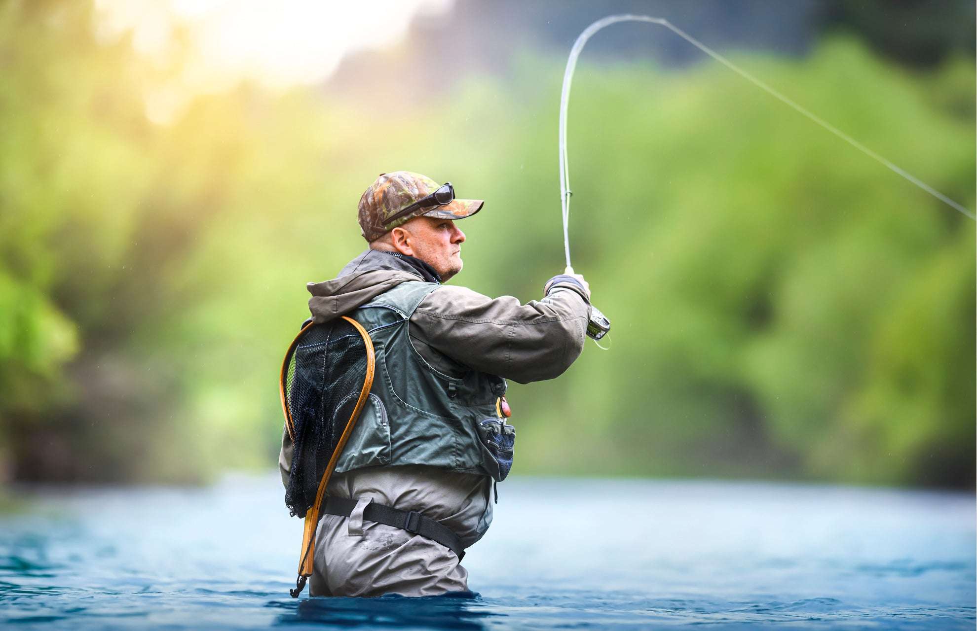Angler casting a line while fishing in a river using a Dahlberg diver bass fly to attract fish