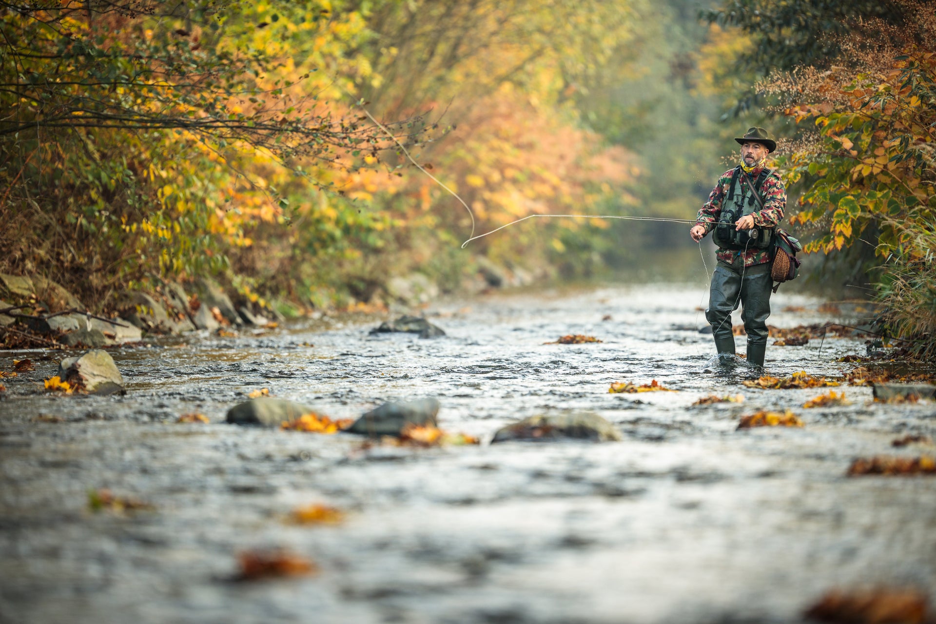 Angler fishing with San Juan Power Worm wet flies in a beautiful autumn stream environment